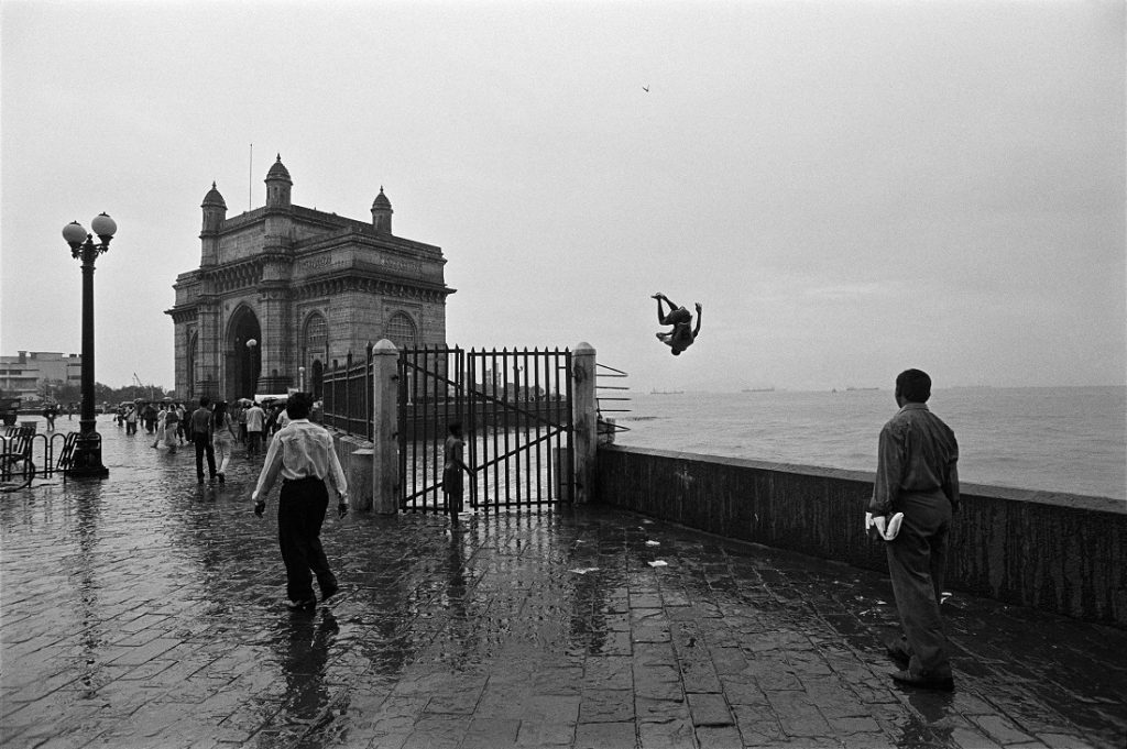 One of those monsoon afternoons when the Arabian Sea is at it’s roughest and the winds are gusty and the skies are an ominous grey presented an opportunity for this young man to enthusiastically practice his dangerous stunt of leaping into the sea. Around the Gateway of India. Mumbai; Maharashtra. 1995.